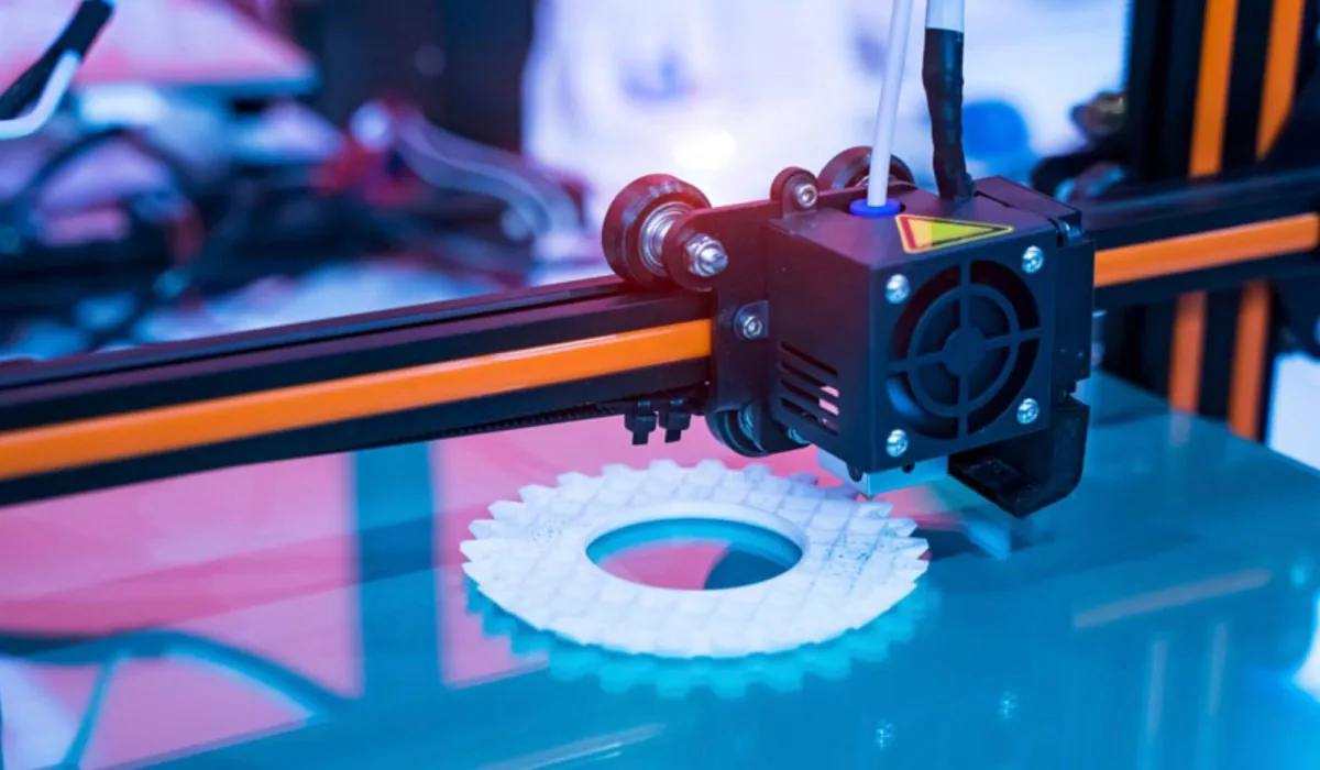 Głowica drukarki 3D pracująca nad białym kołem zębatym